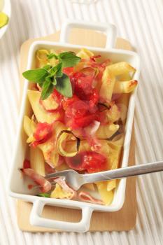 Pasta with ham and cheese topped with crushed tomatoes