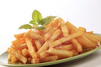 Heap of French fries  on a green plate