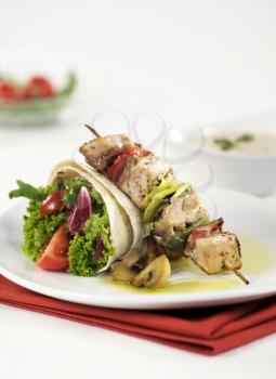 Shish kebab and tortilla filled with vegetables 