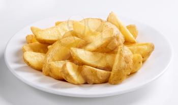 Crispy baked potato wedges on plate