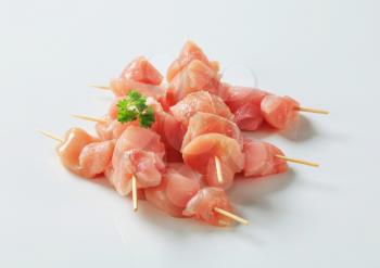 Pieces of raw chicken meat on skewers
