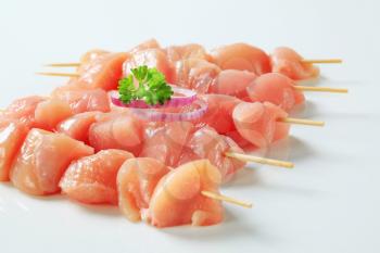 Pieces of raw chicken meat on skewers