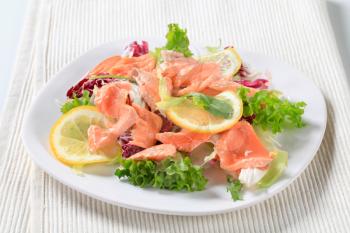 Green salad with pieces of smoked trout