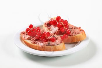 Slices of bread with liver pate and red currants