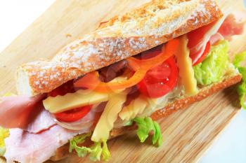 Ham and cheese sub sandwich on cutting board