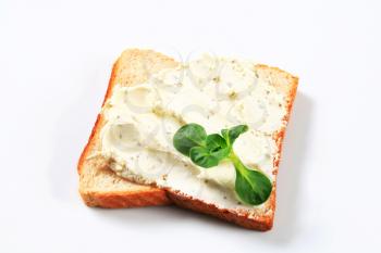 Slice of white bread with cheese spread