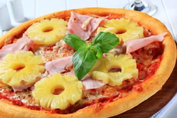 Pizza with pieces of ham and pineapple