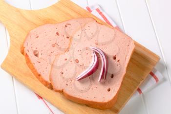 Slices of cold luncheon meat on cutting board