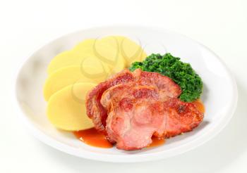 Pan roasted smoked pork neck with potato dumplings and spinach
