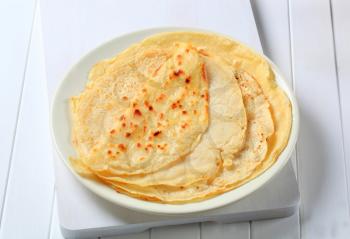 Stack of thin crepes on plate