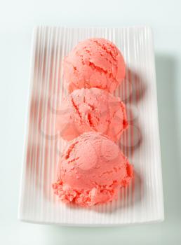Scoops of strawberry ice cream on plate
