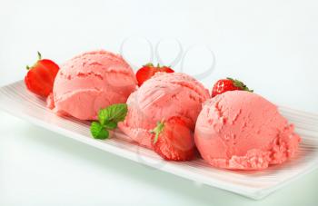 Scoops of strawberry ice cream and fresh strawberries