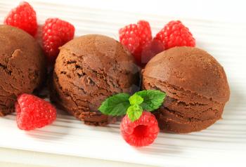 Scoops of chocolate ice cream with fresh raspberries