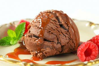Scoop of brownie ice cream with toffee sauce and raspberries