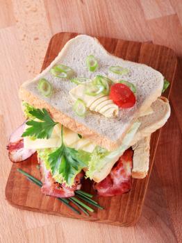 Bacon and cheese sandwich on a cutting board
