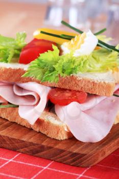 Detail of a ham sandwich on a cutting board