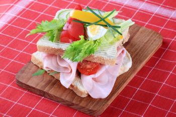 Detail of a ham sandwich on a cutting board