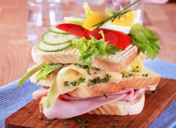 Ham and cheese sandwich garnished with fresh vegetables