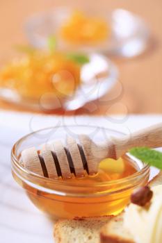 Small bowl of honey and honey dipper