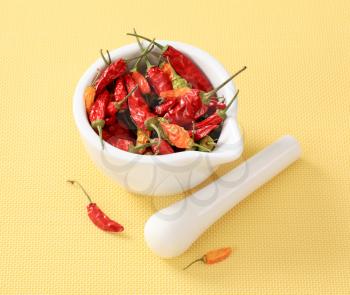 Dried chili peppers in a ceramic mortar