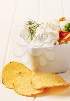 Corn chips and bowl of curd cheese