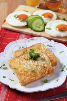 Two pieces of French toast and fried eggs