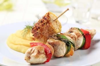 Chicken shish kebab and roasted corn cob with mashed potato