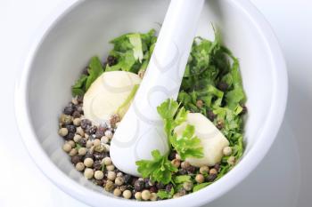 Garlic, parsley and peppercorns in a mortar
