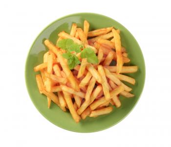 Portion of ready French fries on a green plate