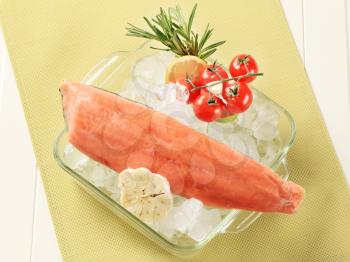 Salmon fillet on ice in a glass dish