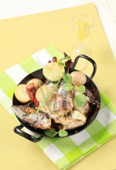 Pan fried mackerel with cream sauce and new potatoes in a skillet