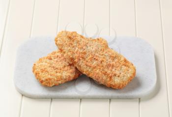 Breaded fish fillets on a cutting board