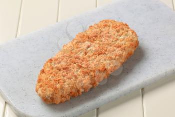 Breaded fish fillet on a cutting board