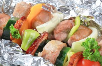 Pork and vegetable skewers in aluminum foil