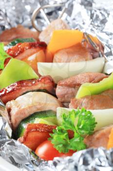 Pork and vegetable skewers in aluminum foil