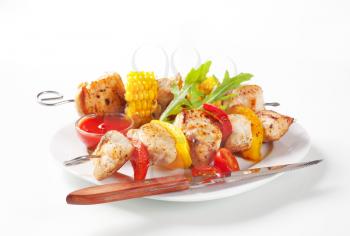 Grilled meat and vegetable on skewers and ketchup