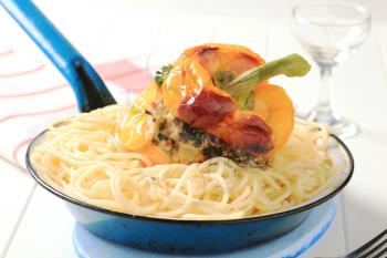 Yellow bell pepper stuffed with ground meat on bed of spaghetti