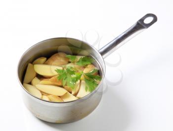 Wedges of new potatoes in a saucepan