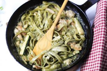 Spinach pasta and chicken meat in cream sauce