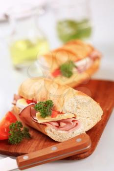 Ham and cheese submarine sandwich on a cutting board