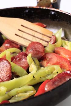 Preparing sausage and vegetable stir fry - detail