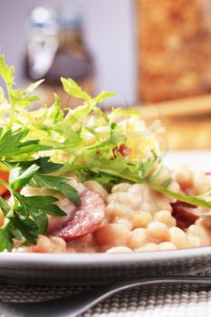 White beans and sausage garnished with greens