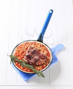 Smoked pork ribs with baked beans in a pan