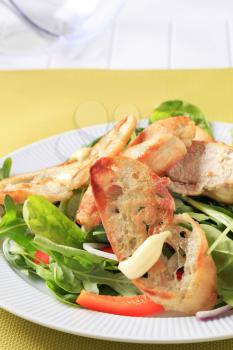 Salad greens with pieces of chicken and crispy ciabatta