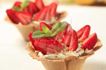 Pastry cups filled with cream and fresh strawberries