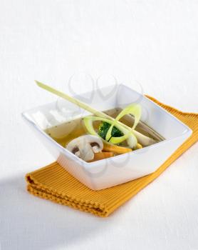 Soup with vegetables in a square bowl