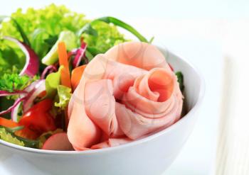 Fresh salad with slices of ham arranged into a rose