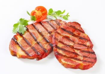 Slices of grilled pork neck on white background