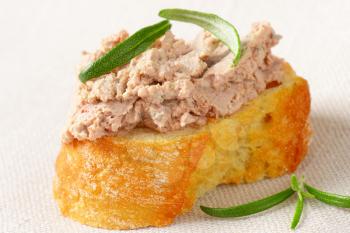 Slice of crunchy baguette with chicken liver pate