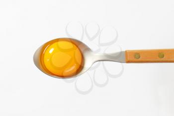 Raw egg yolk on a spoon